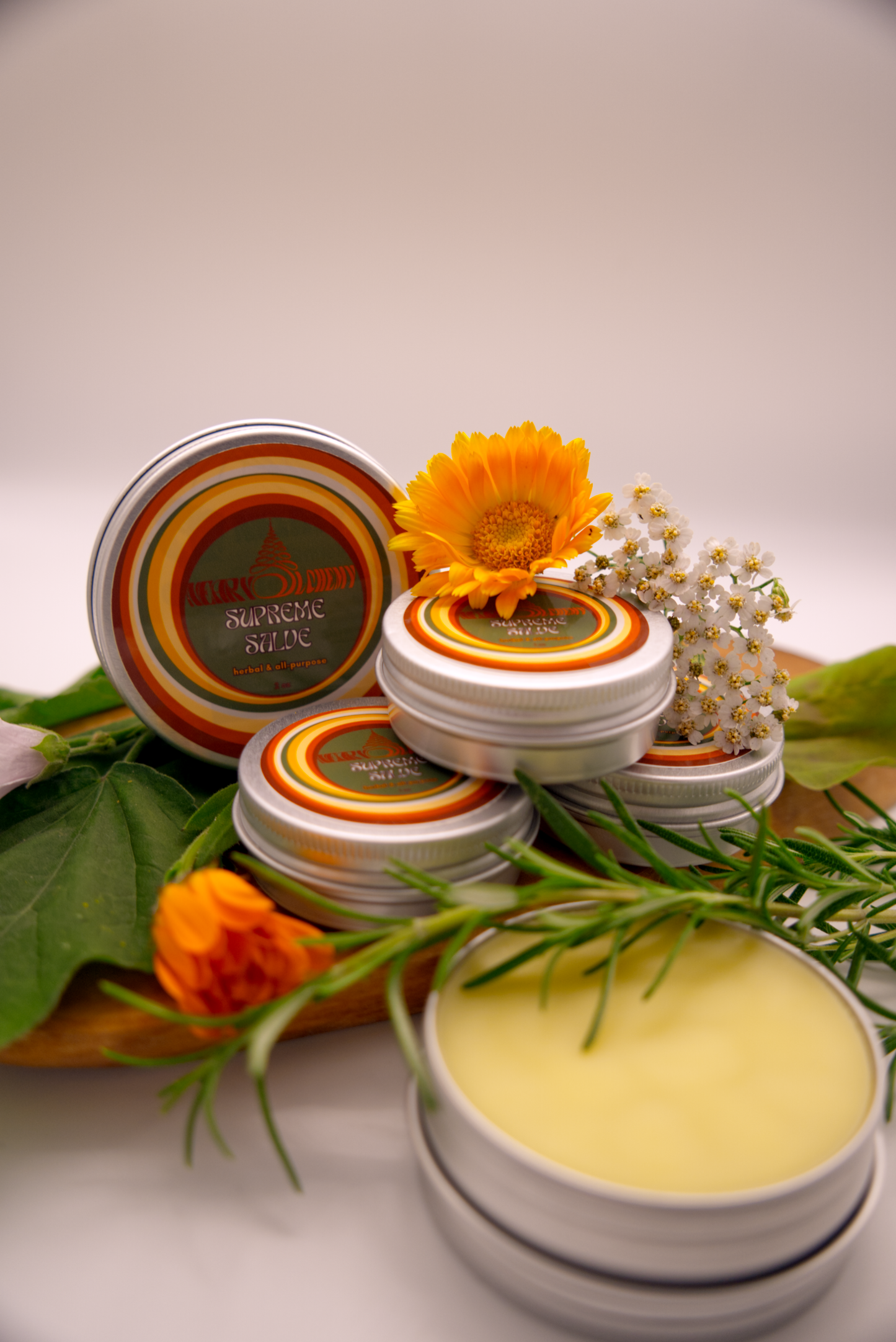 Supreme Salve tins with floral decorations on a white background
