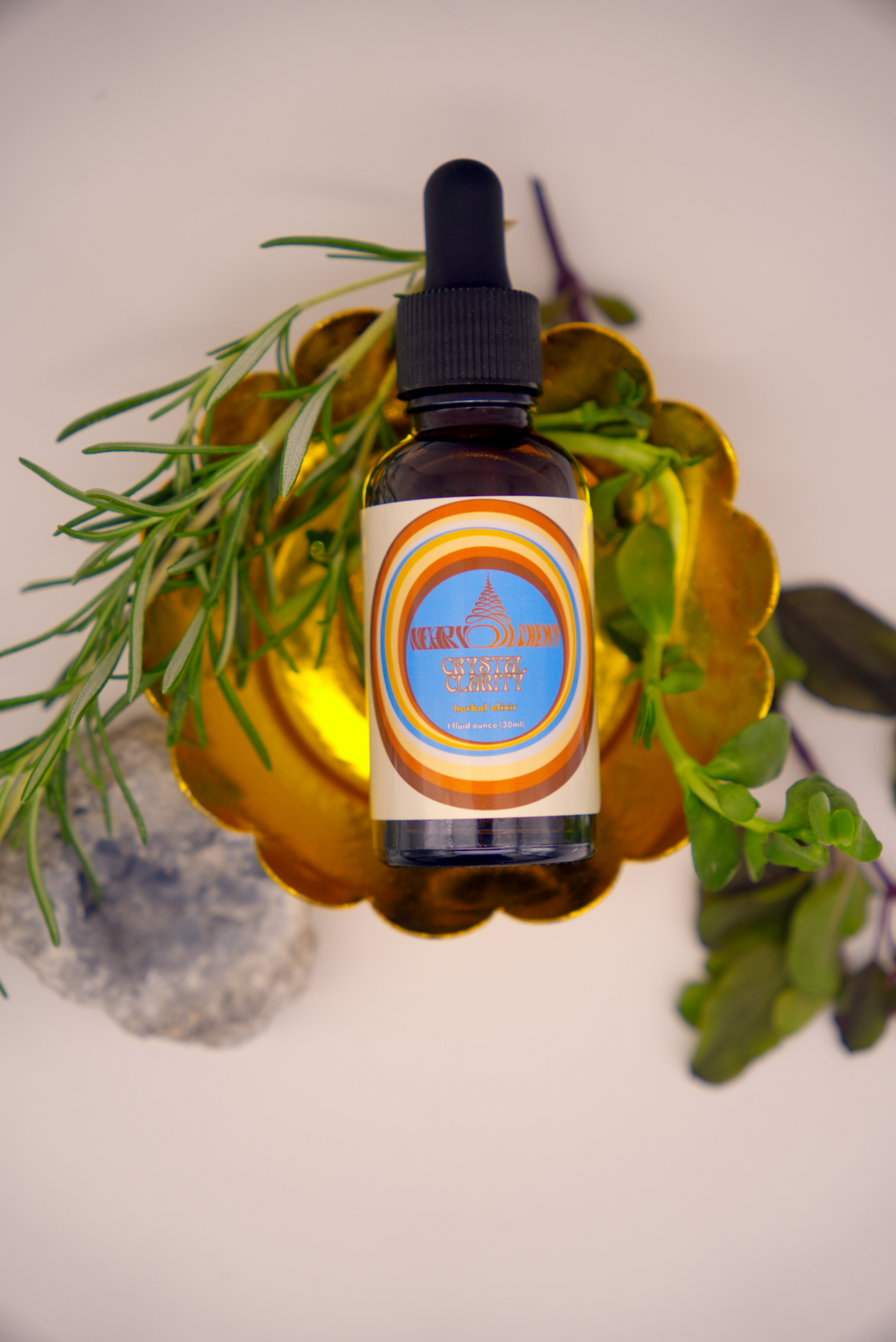 Crystal Clarity Herbal Elixir on decorative stand surrounded by herbs and Celestite crystal.