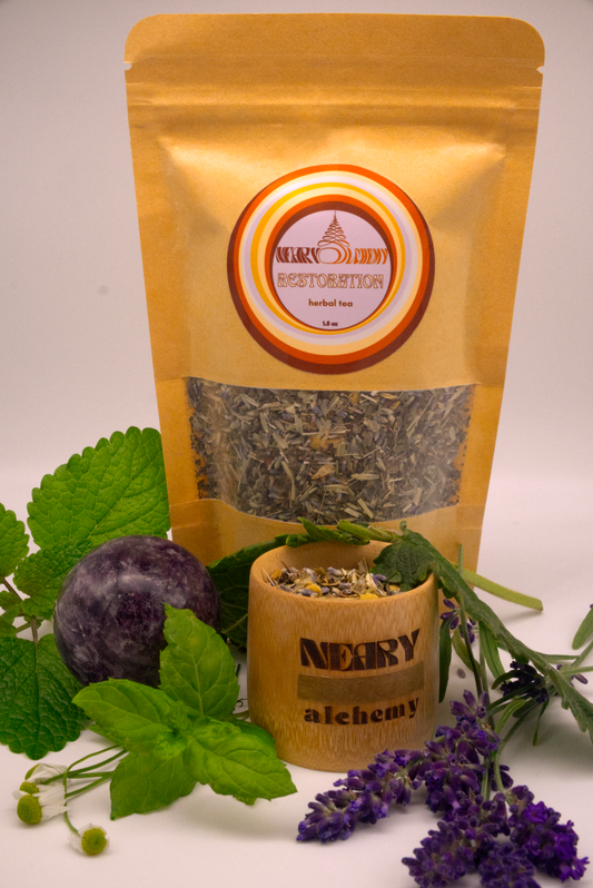 Restoration Herbal Tea package surrounded by lemon balm, peppermint, lavender, and other herbs with Lepidolite crystal sphere.